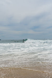 Surfers on the sea, turquoise water, blue sky. arugam bay, sri lanka. portrait format