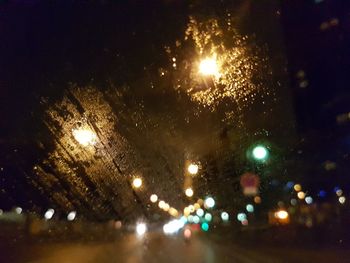 Defocused image of illuminated city against sky at night