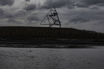 Electricity pylon on land against sky