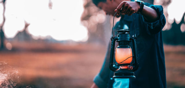 Close-up of man holding lantern