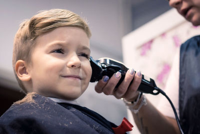 Close-up portrait of boy holding camera