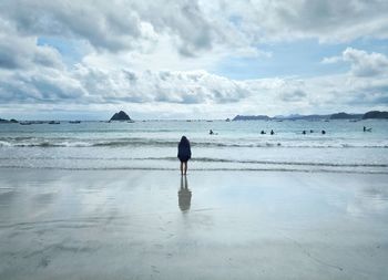 Rear view of woman standing at beach