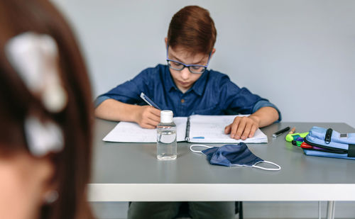 Portrait of boy sitting on table