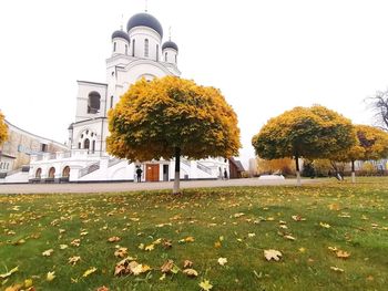 View of autumn trees and building against sky