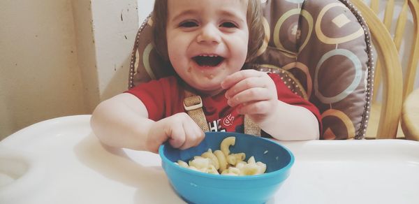 Cute boy eating food in bowl