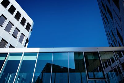 Low angle view of modern building against clear blue sky