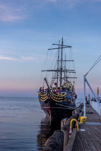 Sailboat moored in sea against sky
