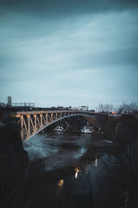 Bridge over river against sky at night
