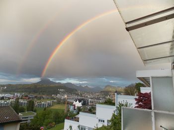 Scenic view of rainbow over residential district