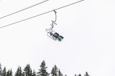 Low angle view of overhead cable car against clear sky