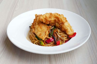 High angle view of fried chicken with pasta in plate on table