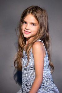 Portrait of smiling girl against gray background