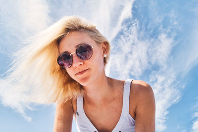 Portrait of woman wearing sunglasses against sky