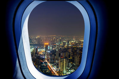 Illuminated buildings seen through window