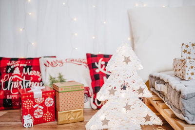 Christmas decoration at home. chimney, gifts, tree, noel, cushions on beautiful indoor white studio.