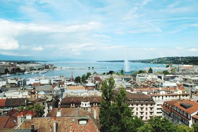 Town by lake geneva with fountain against sky