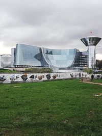 View of modern buildings against cloudy sky