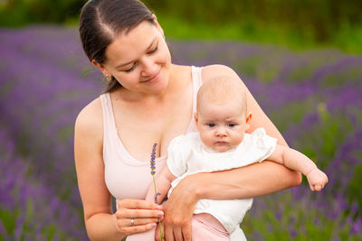 Portrait of mother and daughter on purple flowering plants