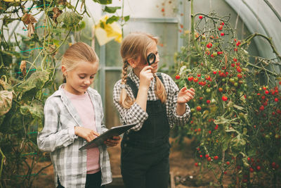 Young woman standing against plants