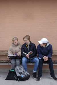 School friends sitting on bench and studying