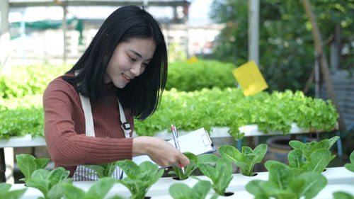 Young woman looking away while plants in park