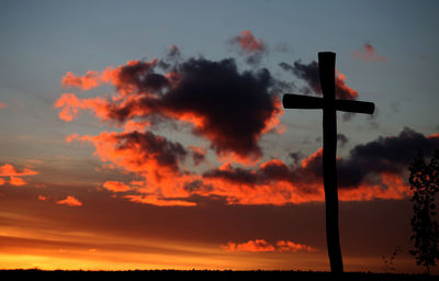 Low angle view of silhouette cross against sky during sunset