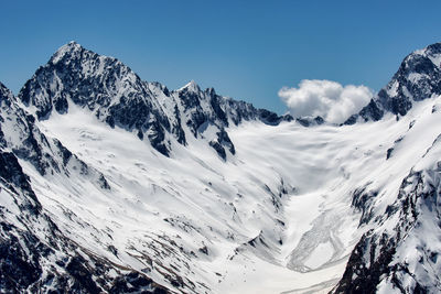 Scenic view of snowcapped mountains against blue sky