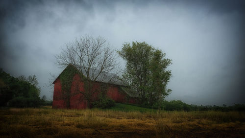 Abandoned house on field against sky