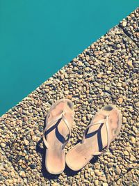 Close-up of shoes on sand at beach