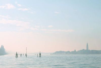 View of boats in sea against cloudy sky