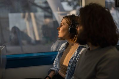 Rear view of woman looking through window