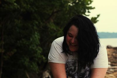 Smiling woman against trees