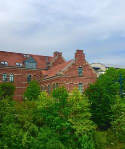 Low angle view of trees and buildings against sky