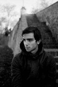 Close-up of young man looking away while standing outdoors