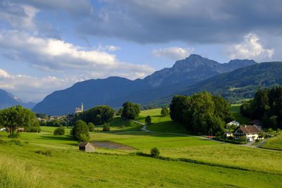 Scenic view of green landscape and mountains against sky