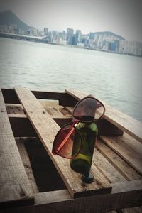 Close-up of sunglasses on table by river in city