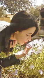 Close-up of woman with flowers in background