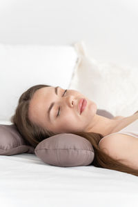 A girl sleeping on a special beauty pillow with a silk pillowcase. vertical photo with copyspace