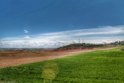 Scenic view of grassy field against cloudy sky