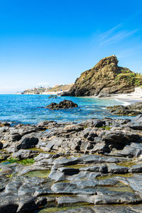 Rock formation on beach against sky