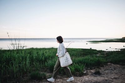 Rear view of man looking at sea against sky