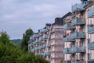 Low angle view of buildings against cloudy sky