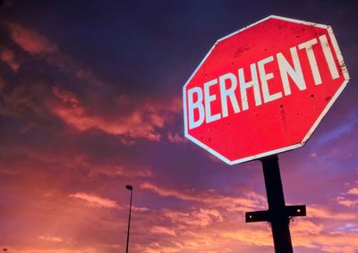 Low angle view of road sign against sky