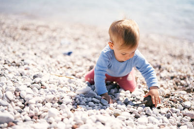 Full length of boy on pebbles at beach