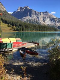 Boats moored by jetty at emerald lake