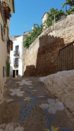 Street amidst buildings against blue sky