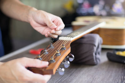 Midsection of man playing guitar