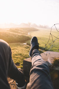 Low section of man on landscape against clear sky