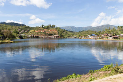 Scenic view of lake by buildings against sky