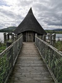 View of footbridge against cloudy sky